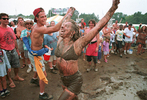 Campers at the Philadelphia Folk Festival celebrate a downpour by sliding through the mud.