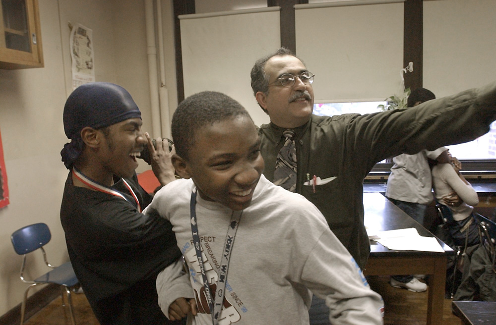 In a class that has students from a half dozen countries, and speak 6 different languages, Jose Diaz has the students link arms to explain the principles involved in molecular bonding. Zaphkiel Tanis left, and Robenson Sander center, both from Haiti are transformed into a pair of molecules.  