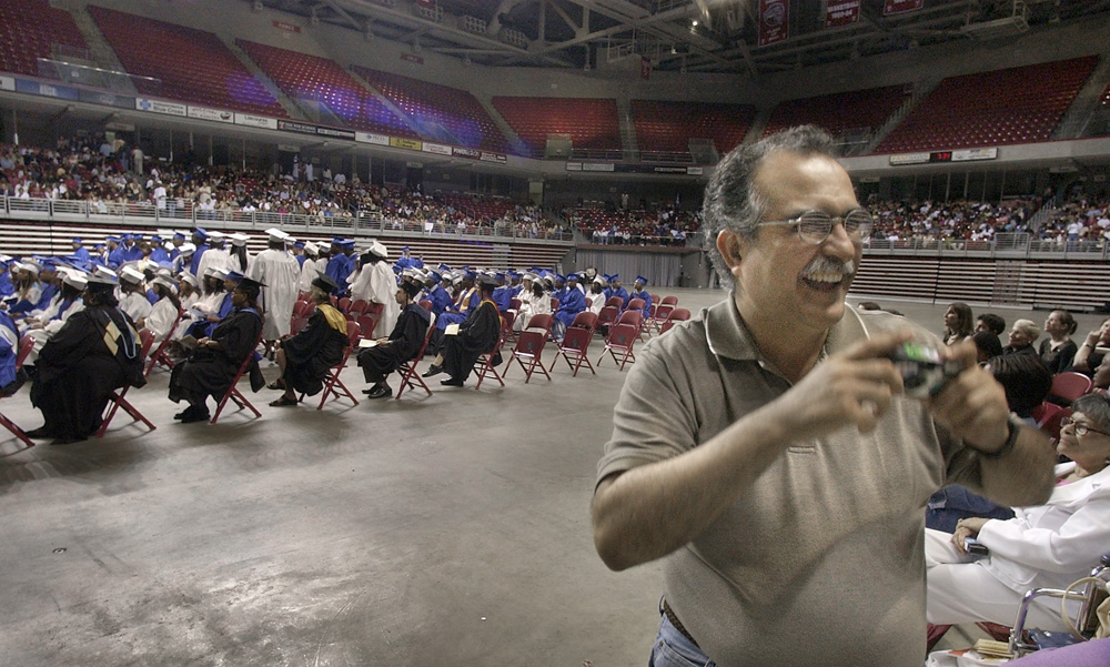 With his many frustrations temporarily forgotten, Jose Diaz took pictures of the students he taught at the Olney High School graduation.