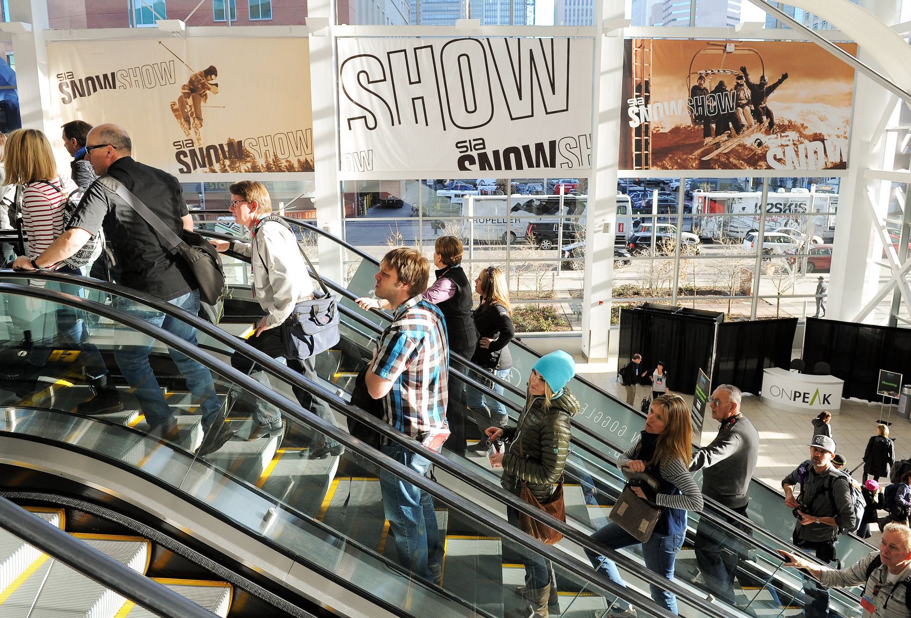 SIA Snow Show attendees ride the escalator to the floor show at the Colorado Convention Center.