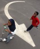 Ihsan Abdussabur chases Layla McMillan across the Masjid Al-Islam parking lot during a fundraiser for Omar Ibn Said Leadership Academy.