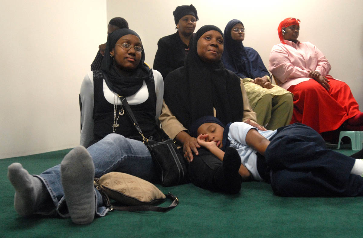 Khadijah Muhammad, center, and her daughter Amirah Muhammad, 19, left, listen to then-mayoral candidate Scott Jackson at the Islamic Center of Hamden in September.  Azizah Muhammad, 8, bottom right, seems less interested.  