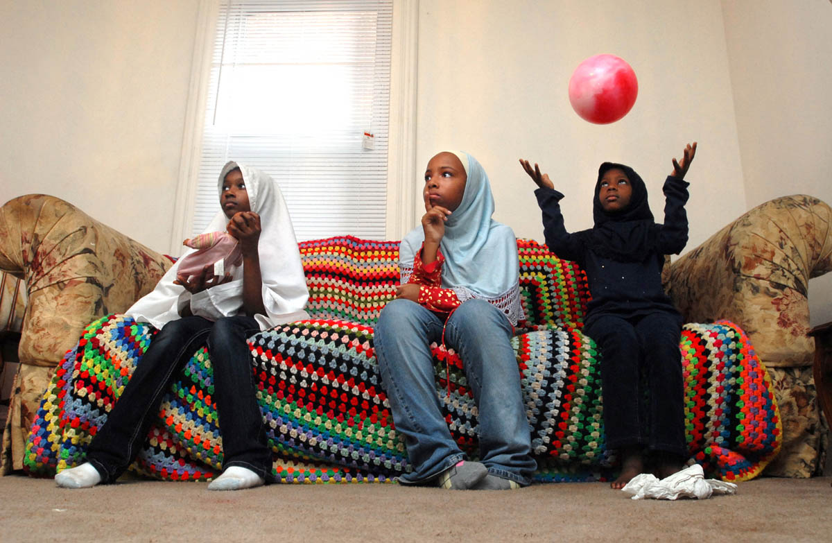 Muslima Girl Scouts Zahra Abdush-Shakur, 7, Leah Jackson, 11, and Nasira Abdush-Shakur, 5, wait on the couch between activities.  