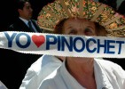 A supporter of former-dictator Augusto Pinochet supporter outside his home on his 90th birthday.  