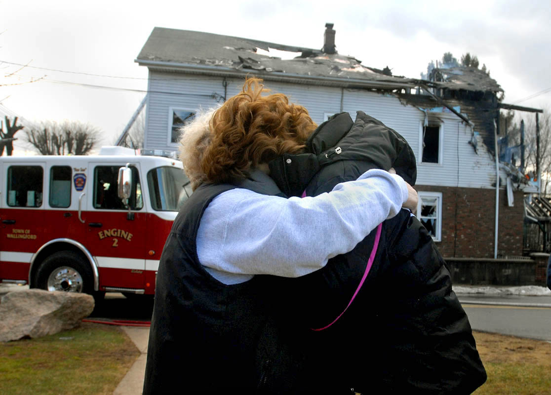 Joyce Perillo, right, gets a hug from her aunt Gerri Tuck, left, at the scene of the blaze at Perillo's Wallingford, CT home.  