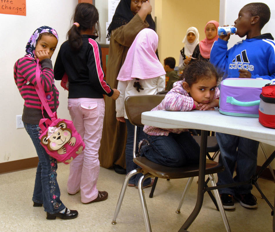 As students line up to leave the cafeteria, kindergartener Arshiya Mohamed, seated, appears displeased. 
