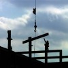 An ironworker reaches up to grab a steel beam as it is lowered into place during construction of an office building  in Bridgewater, New Jersey. 