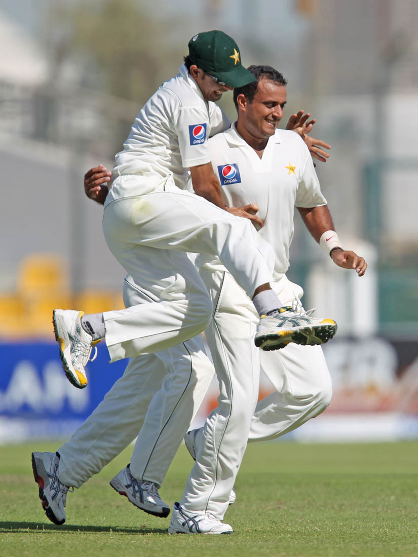Pakistan's Tanveer Ahmed, right, celebrates with teammate Abdur Rehman, left, after taking the wicket of South Africa's captain Graeme Smith on the first day of their second cricket test match in Abu Dhabi on Saturday, Nov. 20, 2010.  (AP Photo/Randi Sokoloff)