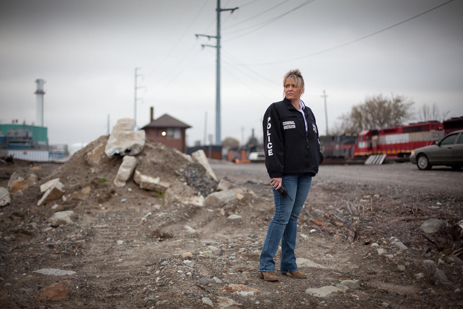 Lowell Police detective Linda Coughlin stands in a vacant field off Maple Street in Lowell, MA in the approximate location where the body of 15 year-old John McCabe was found murdered in 1969. After the reopening of the case, she was successful in receiving a confession from Edward Alan Brown—one of the three men who beat, bound and murdered John McCabe because he flirted with a girl at a dance. 