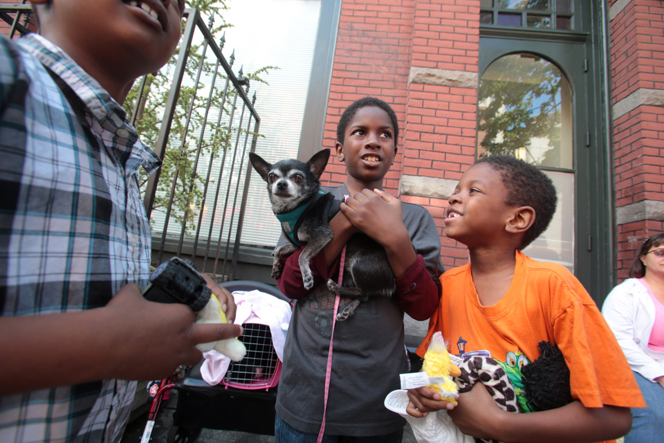 From left to right: Jazzari Watson, 7, Damari Thomas, 9,  and his brother Romel Moore,6, hold Cha Cha, a nine-year old dog they met on line as they wait outside the Doney Memorial Pet Clinic in Seattle, WA on June 25, 2016. They are with their grandmother, Donna Young, and her cat, Kitty, who has blood in her urine to see a veterinarian. The family is currently living in an apartment. (photo © Karen Ducey Photography)Homeless and low income people bring in their pets to see veterinarians and pick up food at the Doney Memorial Pet Clinic located in the Union Gospel Mission in Seattle, WA on June 25, 2016. (photo © Karen Ducey Photography)