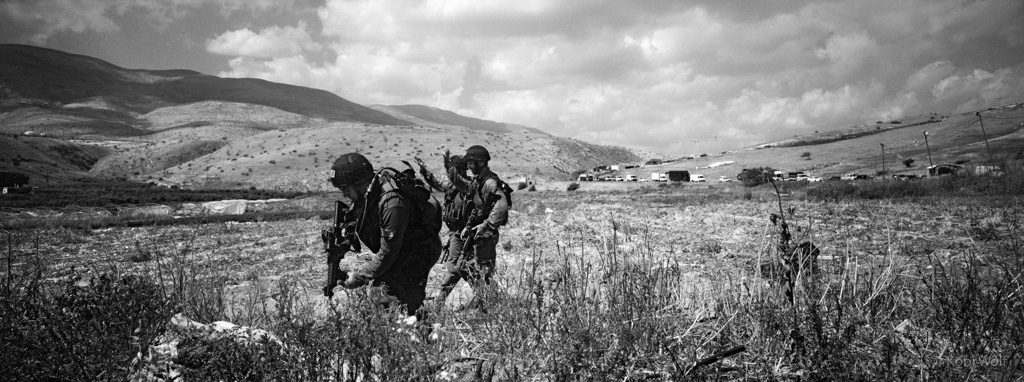 Israeli Soldiers walking on Palestinian farmland during a military exercise.