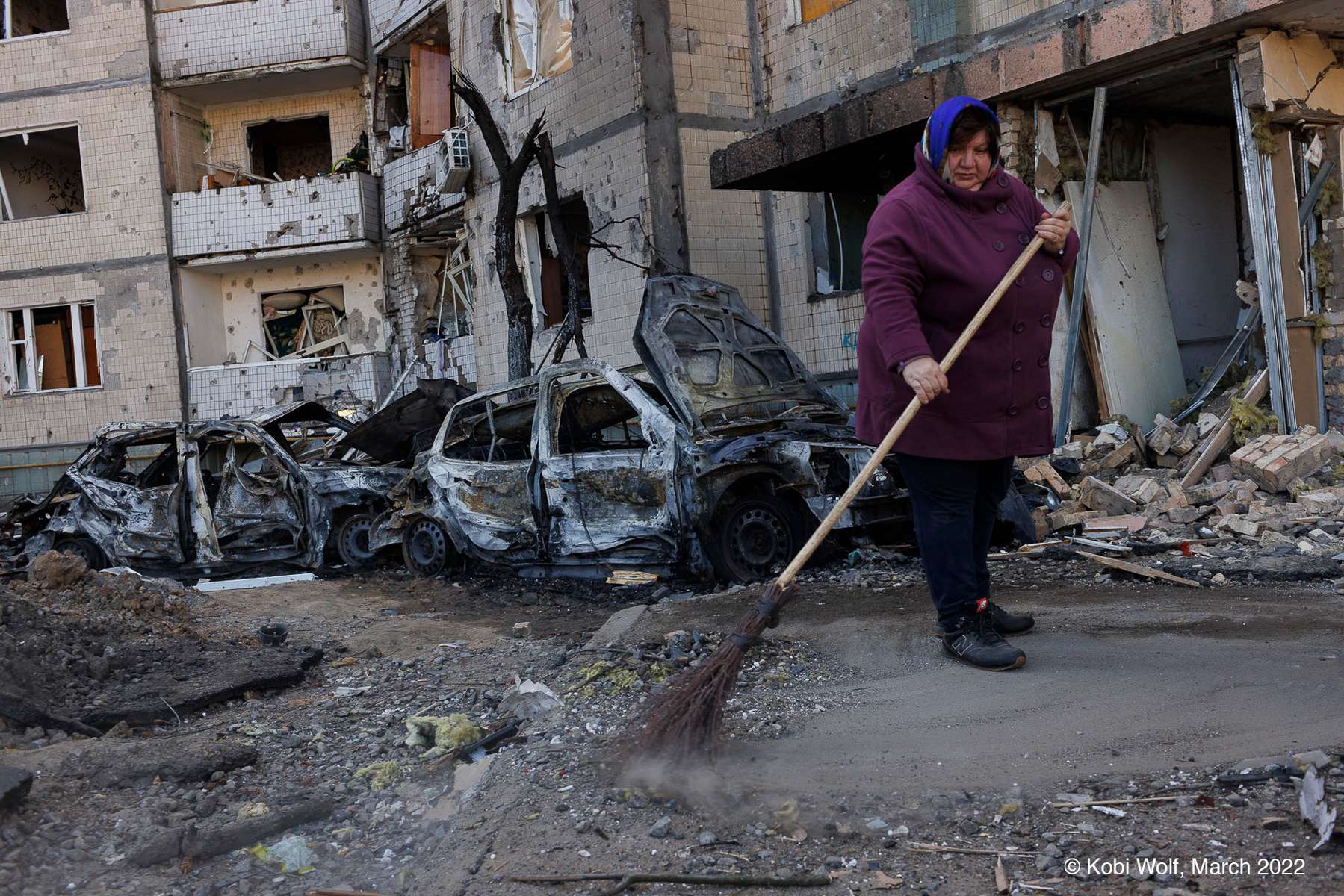 Woman clean around a damaged building  after air-attack by Russia In Kyiv, Ukraine  on March 21 2022  photographer: Kobi Wolf