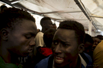 Africans Migrants Fighting for a bottle of water on the deck of the Procativa open arms ship  after being rescued in the central Mediterranean, in international waters off the Libyan coastal town of Sabratha. 