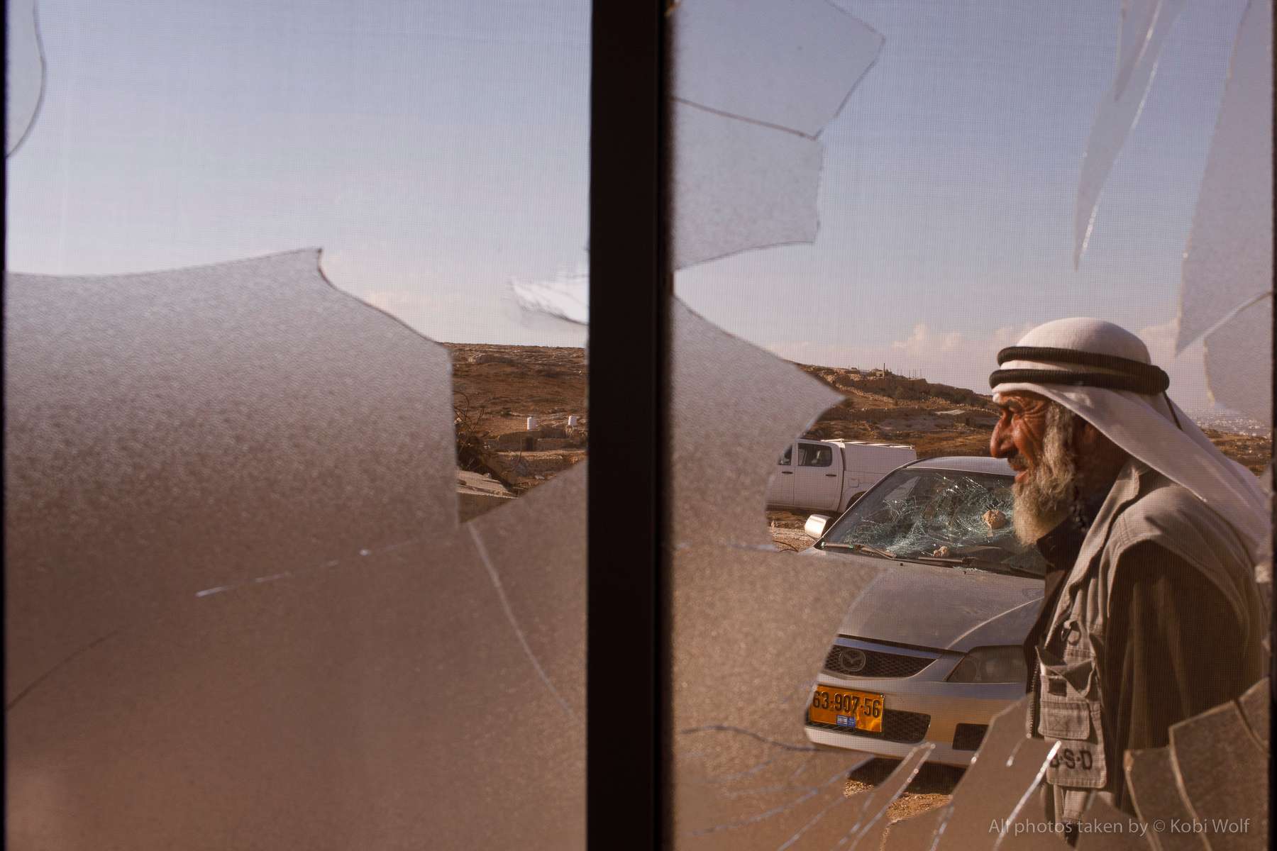 Mahmoud Hussein Hamamdeh, grandfather of the wounded child (Mohammed) as seen from a broken window cause by the attach of Jewish settlers In Al Mufkara village, South hill Hebron, West Bank on Wednesday September 29, 2021 photographer: Kobi Wolf for NRC