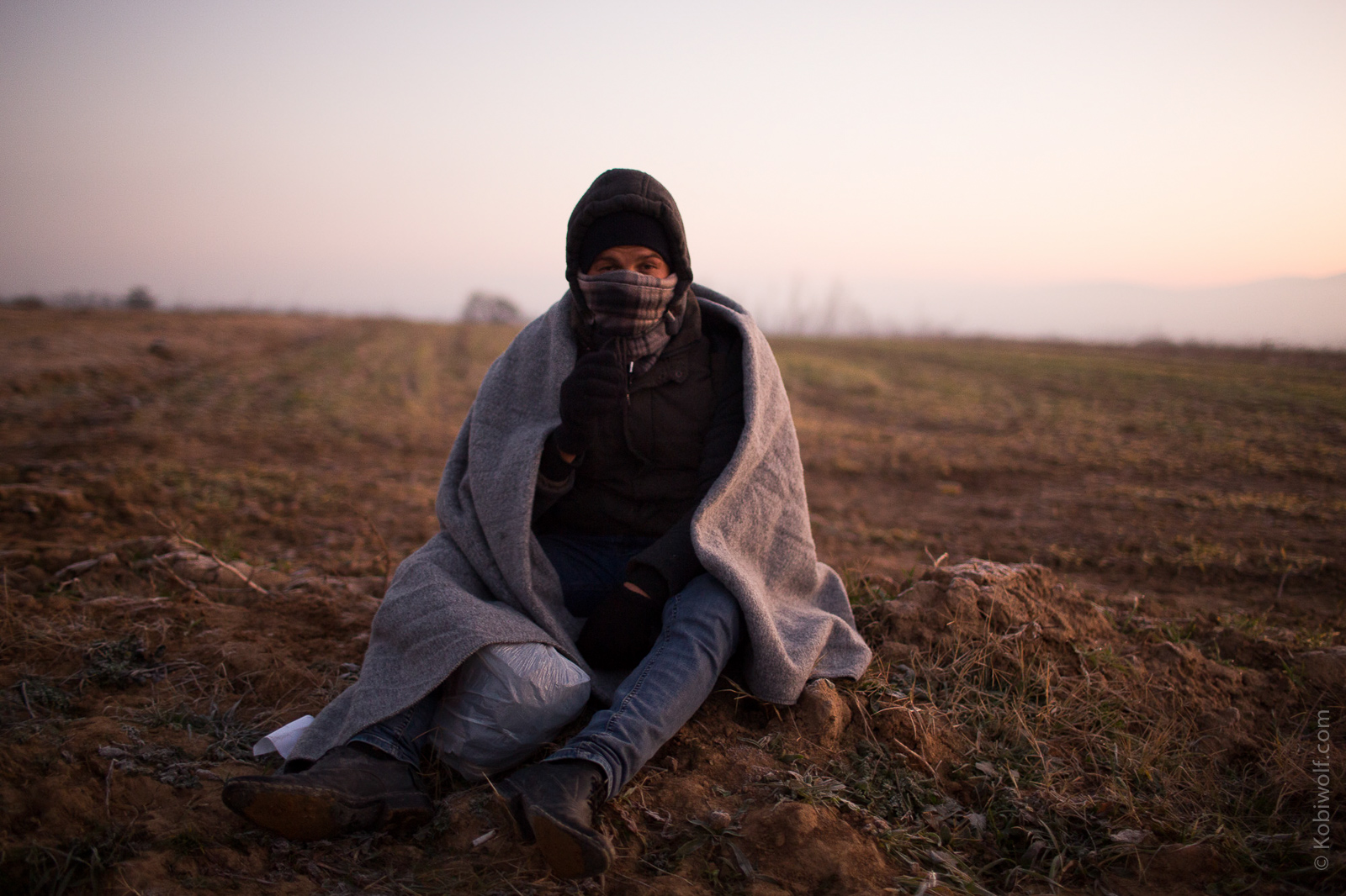 Syrian refugee gathers his strength after 5 km walk from the train station on the Macedonia border and into Serbia.