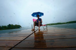 Zach Reidinger, 17, from Lake Forest, Calif., alone on a dock holds an umbrella while on a lawn chair enjoying the pouring rain on his family's dock at Kelly Lake in Suring, Wisc., on September 2, 2010. Reidinger has been visiting the lake every summer since he was 10 years old, but he has never been there in September and definitely felt the difference in the weather. 