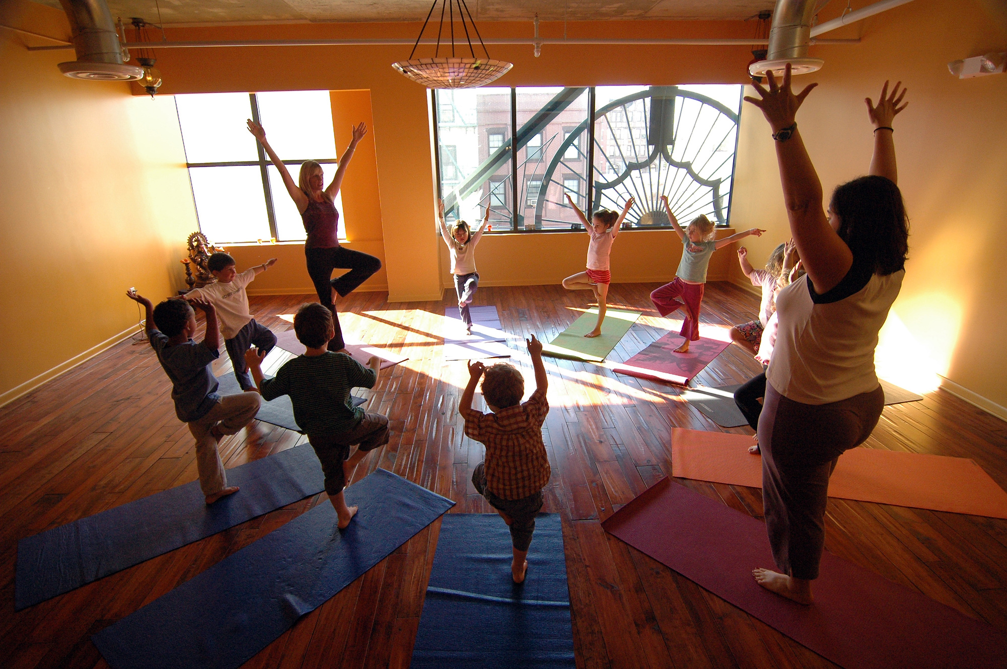 Genie Morrow, upper left hand corner, and Liza Bertini, lower right hand corner, lead a kids yoga class at Devotion Yoga. (Reena Rose Sibayan | The Jersey Journal)