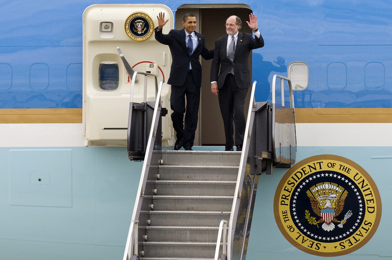 U.S. President Barack Obama and New Jersey Gov. Jon Corzine wave at the top of the steps as they exit Air Force One at Newark Liberty International Airport. (Reena Rose Sibayan | Associated Press)
