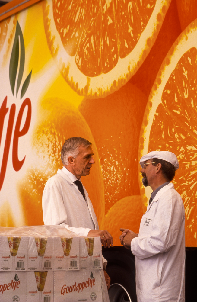 Fruit juice processing specialists and a delivery truck trailer, BelgiumAt a juice plant in Belgium, a process technical consultant and a plant supervisor stop to talk beside a delivery truck trailer.