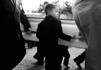 Seven-year-old Mac and six-year-old Ryan, on the other side of the casket, step in as pallbearers, helping to carry their sister from the hearse to the cemetery.