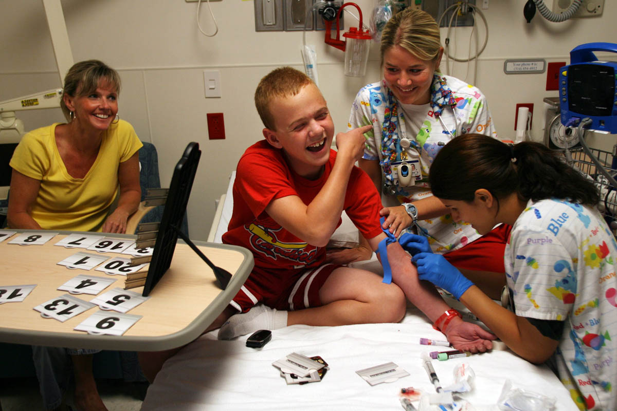 {quote}You're not gonna get it{quote} Brendan says as he taunts nurses Meghan Miller, center,  and Rachel Elledge, right, as they tried to put in an intravenous line for his Immuno Globulin treatment (IVIG) at St. Louis Children's Hospital. The IVIG treatment infuses about 20,000 antibodies for 20,000 people into Brendan's body. Also pictured is him mother, Krista Staub.