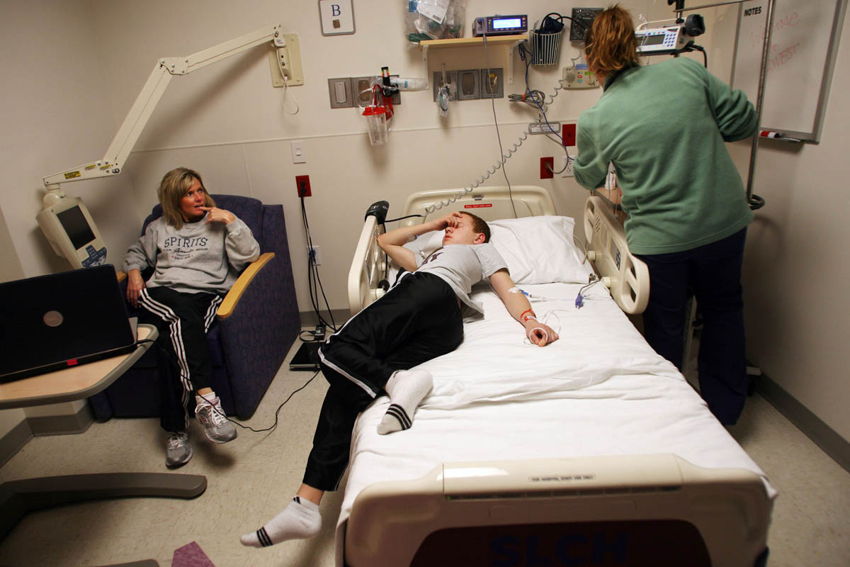Krista Staub looks on as RN Amy Shreves checks on the bag for the Intravenous Immuno Globulin treatment (IVIG) for her son Brendan Staub at St. Louis Children's Hospital. The IVIG treatment infuses about 20,000 antibodies for 20,000 people into Brendan's body. The treatment can take up to 24 hours to administer. 