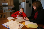 Homebound teacher Claire Kujath helps Brendan with his math homework over Christmas break. Because Brendan misses so much school with his medical appointments and treatments he has teachers come to his house to help him keep up.