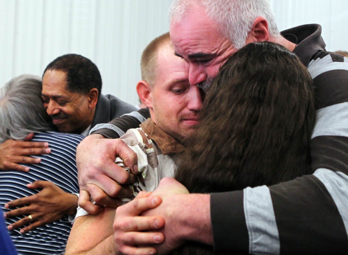 Far right, Tom Fuller hugs Nicole Caraker and her fiance Matthew Standfield after Shiloh Baptist Church's congregation held their service at Glad Tidings Church in Catawissa. Shiloh Baptist Church was severely damaged during the tornadoes that struck the area New Years Eve. {quote}God does everything for a reason,{quote} Fuller reassured his friends. Also pictured in the background is  Rev. George Fulgham hugging Bonnie Kommer.