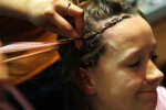 Amber Overton braids Rachel Wessling's hair as they hang out in Overton's dorm room at St. Louis University two days before her fight.  She mixes in strands of synthetic pink hair into the braids in honor of her nickname {quote}The Pink Panther.{quote} 