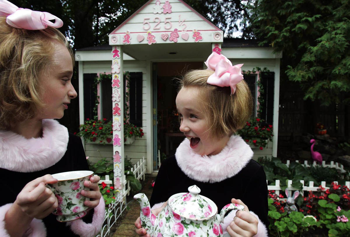 Sisters Suzie, 9, and Sarah Shriber, 7, show off the garden tea house in their backyard. Their mom changes the theme of the house to suit their interests.   