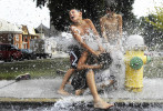 Brent Petrick, 15, Cody Racine, 8, Brandon Petrick, 12, and Bradley Hopkins, 10 pile onto each other at the open fire hydrant near Wirt Park in Hanover. The three brothers and their cousin found the fire hydrant while delivering newspapers and decided to cool down in the gushing water on their way home.
