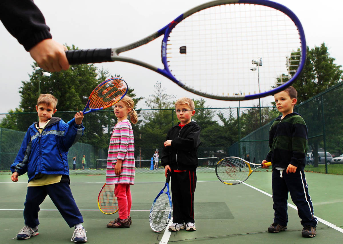 Left to right, David Fletcher, 6, Hallie Pack, 5, Jack Cannon, 5, and Cooper Terrill, 4, watch as instructor Bess Lillmars demonstrates how to hold your racket during a Pee Wee Tennis class for 4 to 6 year olds at Kirkwood City Park. The basic class teaches the kids skills like reaction, balance and control along with serving, forehand and backhand swings. 