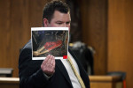 St. Joseph County Prosecuting Attorney John McDonough shows a photograph to the jury of Calista Springer chained to her bed after firefighters were able to extinguish flames that destroyed the family's Centreville home. Calista Springer died in the fire from smoke inhalation.