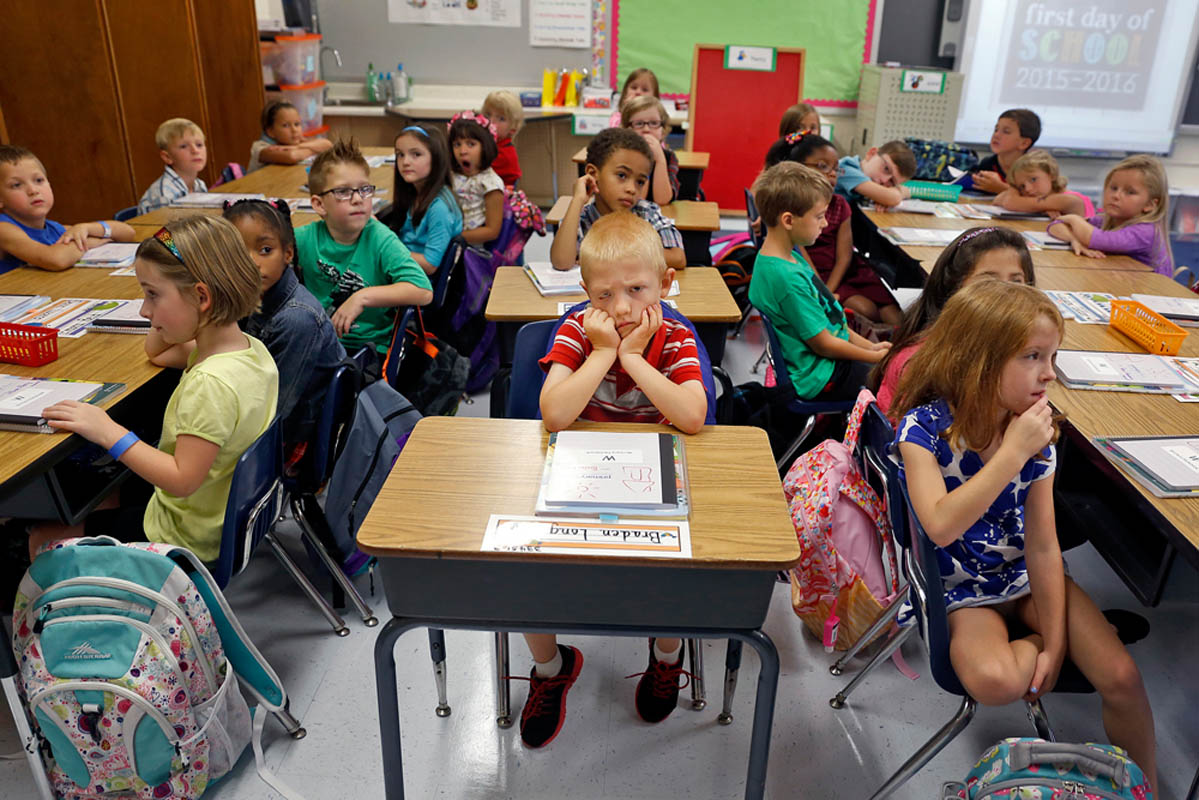 Braden Long, center, holds his head up as school administrators speak to Martha Tereska's first grade class during the first day of school Tuesday morning at Yates Elementary School on September 08, 2015. 