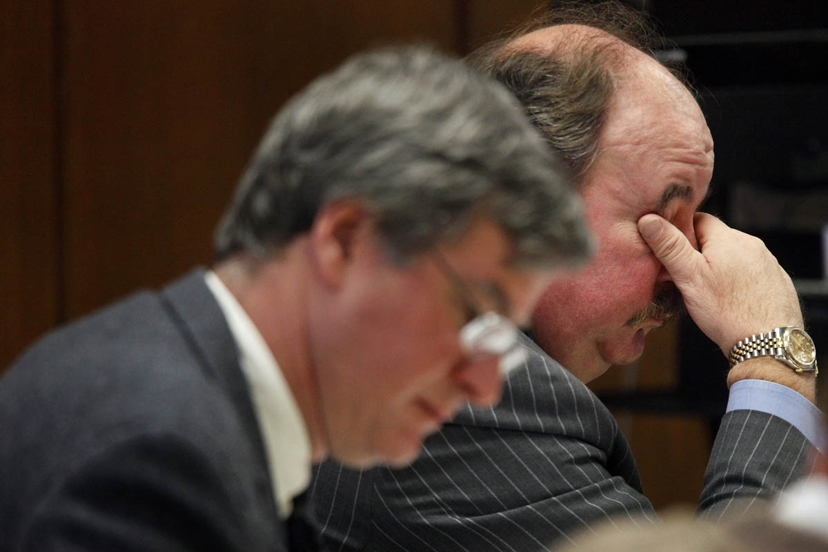 Defense attorney Victor Bland, right, holds his head while sitting next to defense attorney John Bush, left, as they listen to testimony from former Child Protective Services investigator Patricia Skelding. “It was understood that Calista was being chained to her bed,” said Skelding, who worked for 18 years for what is now the Michigan Department of Human Services. “I believe it was known for a long time.” Defense attorneys Bland and Bush contend Calista was a “mildly retarded” child who required drastic measures as she grew older in order to keep her from wandering at night and potentially harming herself.