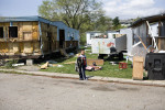 A young boy walks among discarded toys and trash as residents of Franklin Valley Estates mobile home park fill trailers and cars with only their most important possessions. At night over the past month, metal scavengers have come and helped themselves to aluminum siding from abandoned trailers and even from some occupied ones, several park residents said. 