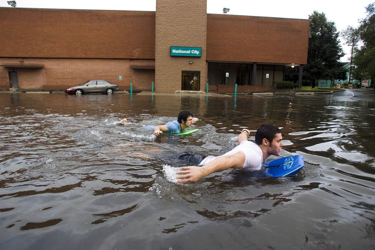 Western Michigan University students Ryan Ehmann, 20, left, and Rusty Good, 19, swim through the National City Bank parking lot on bodyboards after heavy rainstorms caused flooding in parts of Kalamazoo leaving many roads impassable.