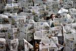 Grand Haven fans hold up newspapers to show their lack of interest as an announcer reads the starting lineup of Kalamazoo Central's basketball team during the 2010 Class A playoff game at Lansing Eastern's Don Johnson Fieldhouse. 