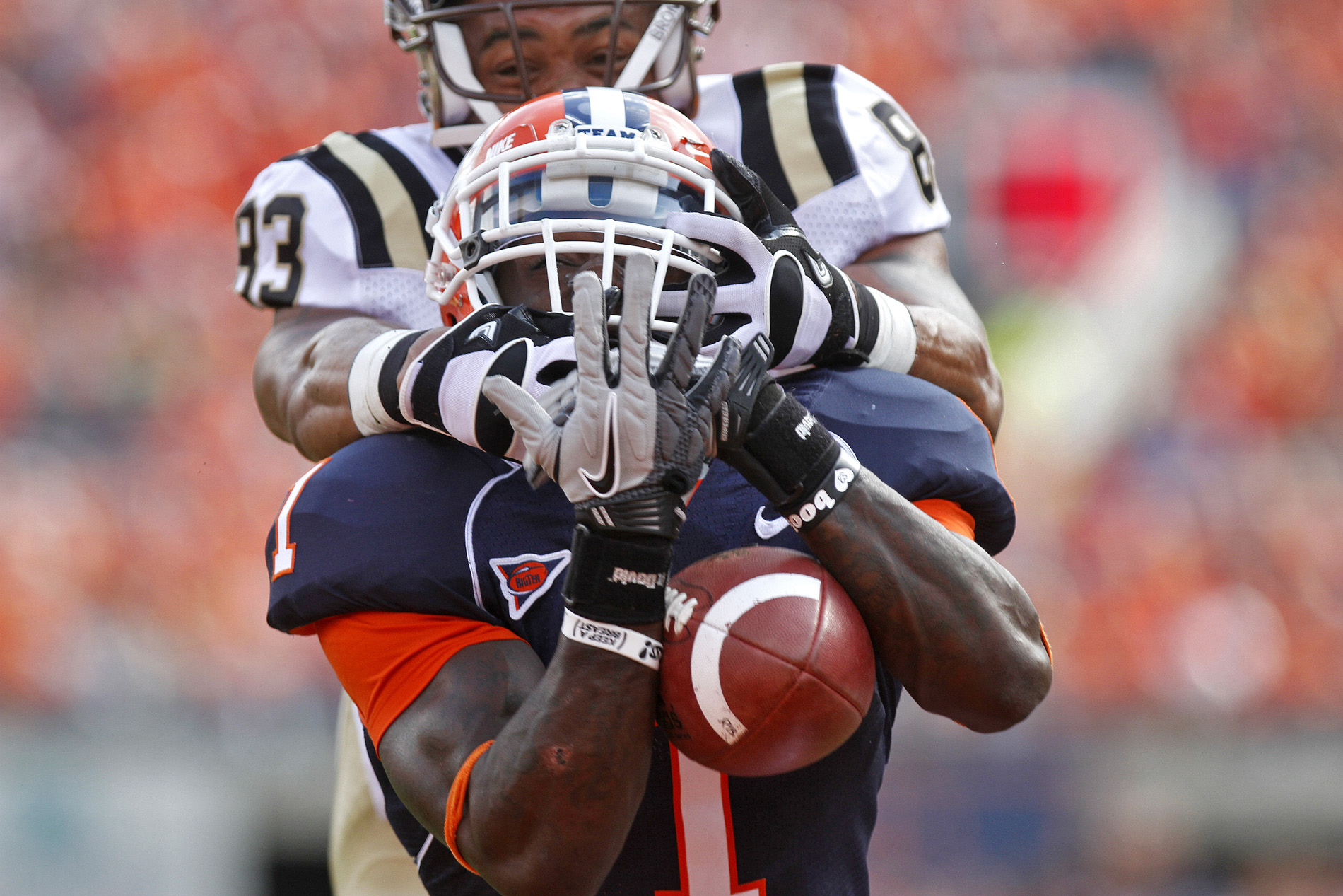 University of Illinois' Terry Hawthorne, center, attempts to intercept a ball intended for Western Michigan University's Jordan White during the September 24 game at Memorial Stadium.