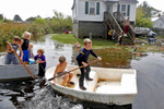 Ryan West, center, paddles a boat with other children through rising flood water in Poquoson Saturday afternoon October 3, 2015.