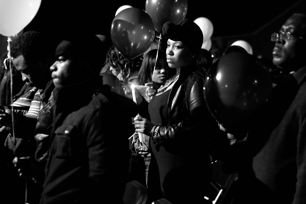 Former employees, friends and family hold candles and balloons during a vigil for Isaac Oshin outside Majik City Gentlemen's Club and Sports Bar Friday evening. Dozens of people gathered outside the club to remember Isaac Oshin who was shot to death inside the club at 5825 Jefferson Avenue Wednesday evening. 