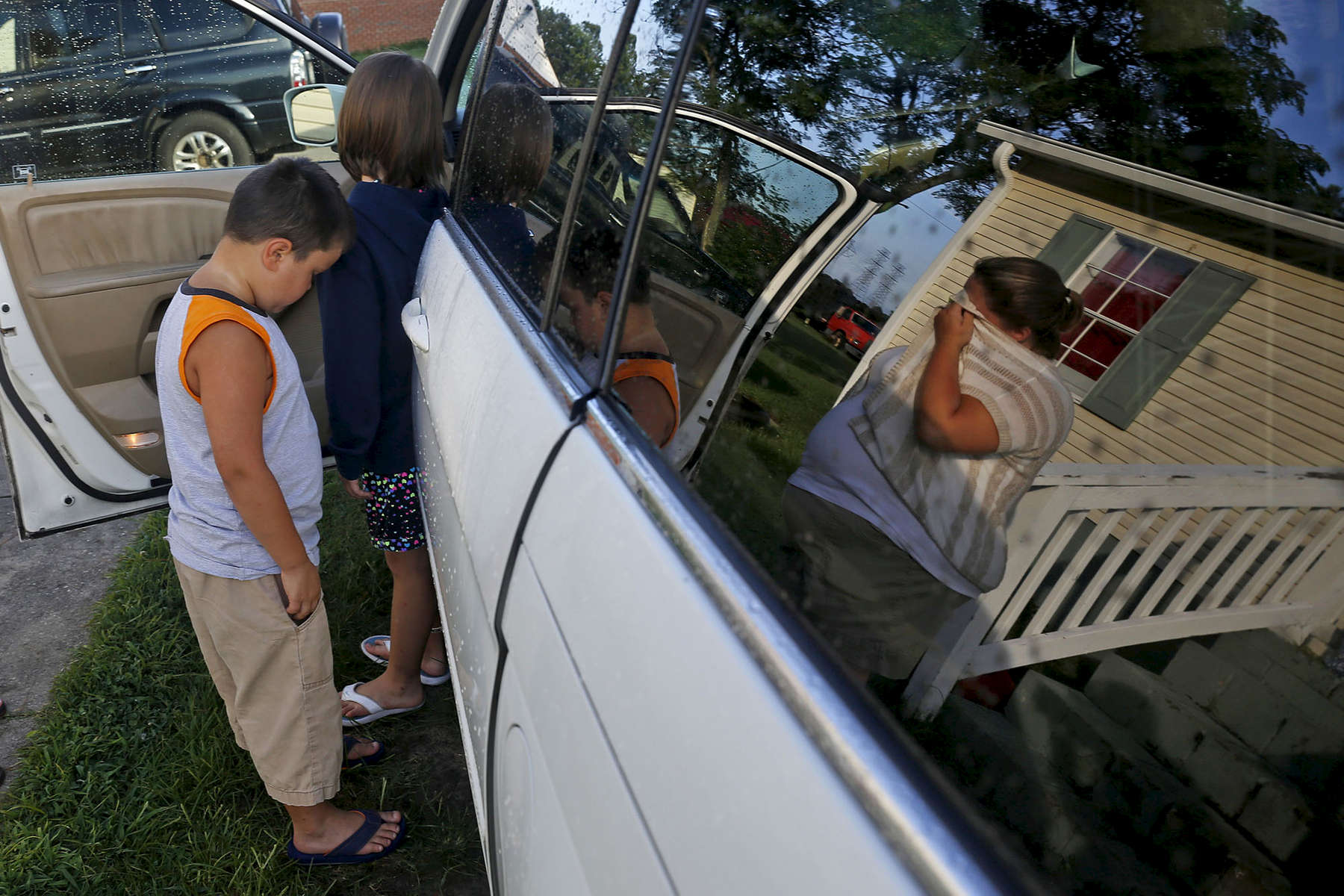 Jessica Leitch, right, begins to cry as Benjamin Leitch, left, and Gracelyn Leitch enter the family's van Sunday morning July 17, 2016 to move to Missouri from Smithfield. Jessica is leaving behind her husband John Leitch in hopes of finding better special education for Benjamin. 