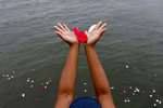 Charmaine Vauters holds her hands to the sky during a flower petal throwing ceremony as part of the 2019 First African Landing Commemorative Ceremony at Fort Monroe Saturday August 24, 2019. 