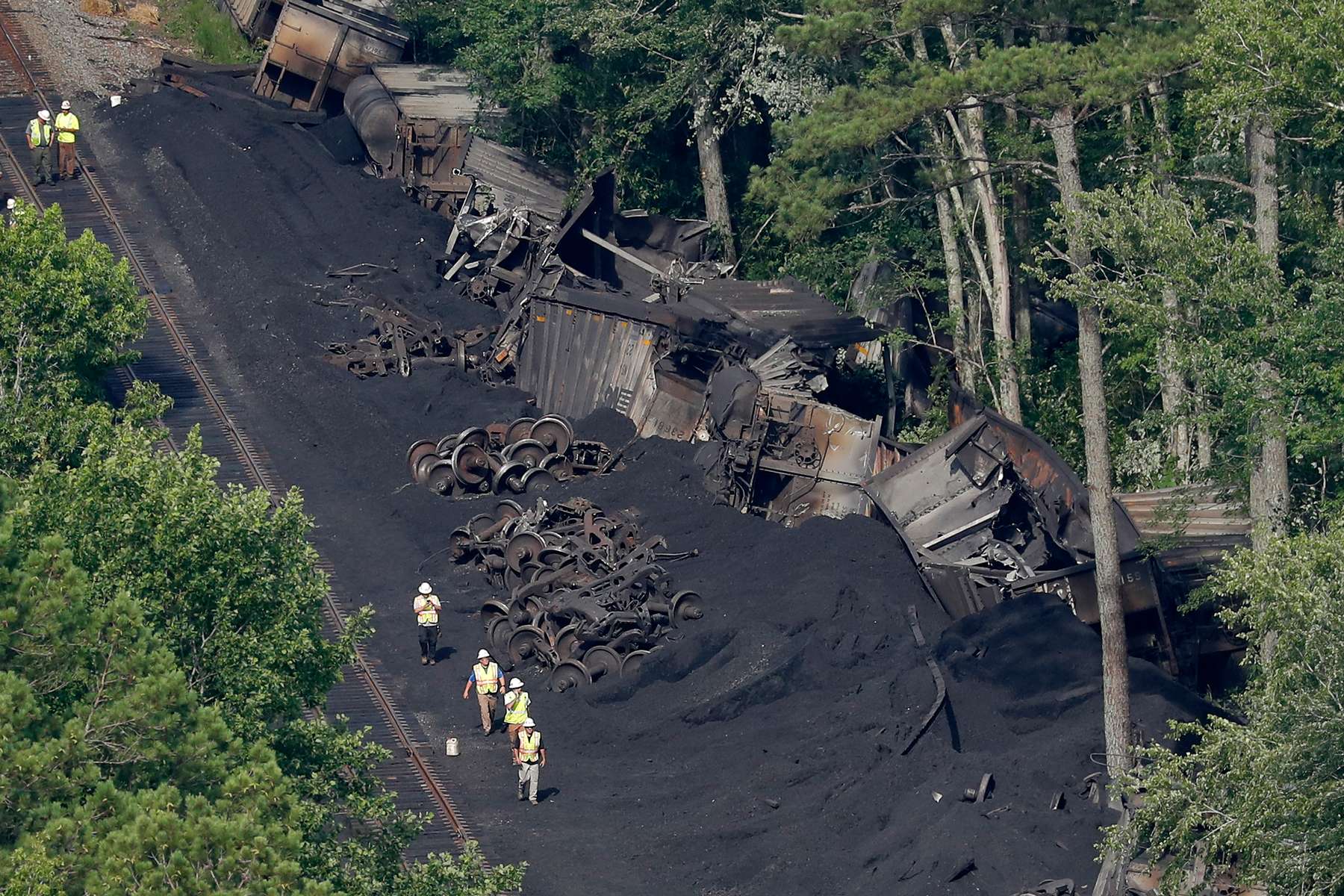 Workers are seen around the site after 36 railroad cars containing 3,600 tons of coal derailed in the Great Dismal Swap Wednesday afternoon June 26, 2019. The train derailed around 4:20 a.m. Tuesday.