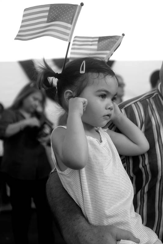 Adelynne MacKenzie, 2, plugs her ears as the U.S. Fllet Forces Band plays prior to the christening of the submarine John Warner SSN 785 Saturday evening at Newport News Shipbuilding. 
