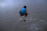 Davidson Ferreira Ferreira, 8, jumps into the Amazon River.