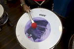A Didá band member with a surdo drum, with the face of Didá founder Neguinho do Samba.