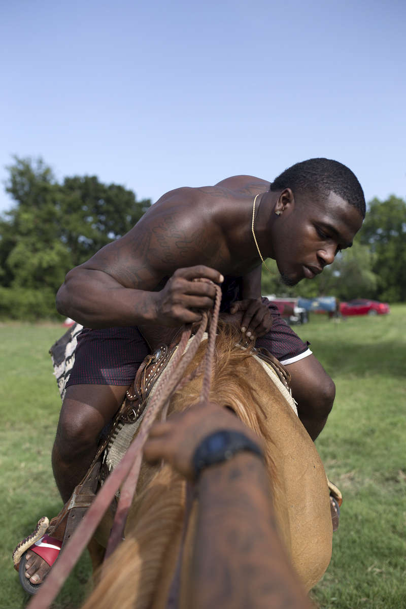 Dee Davis checks out his horse at the trail ride in Calvert, Texas.