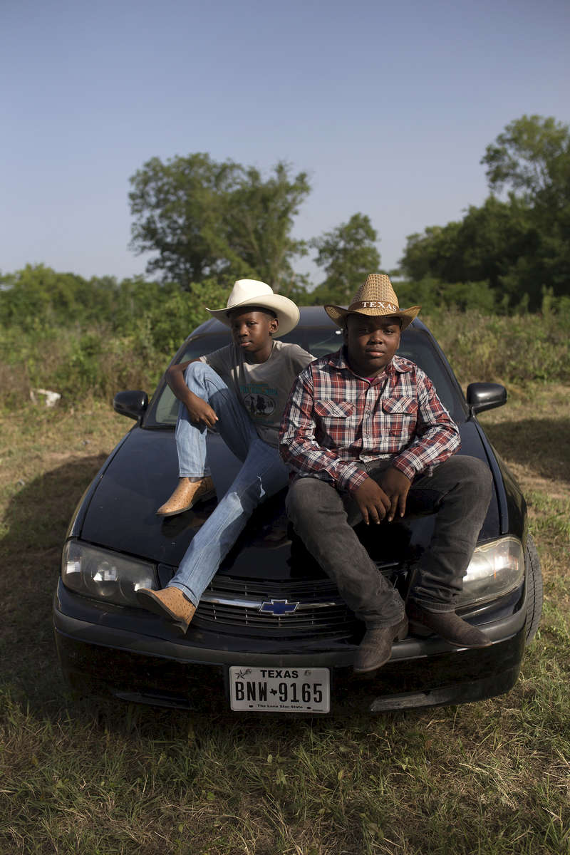 Xavier McNeal and James Wilborn sit on a car at the trail ride.