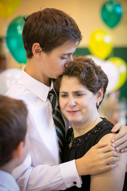 A graduating middle school student hugs his mother who is also the principal of The Mandell School, a private school in Manhattan. 
